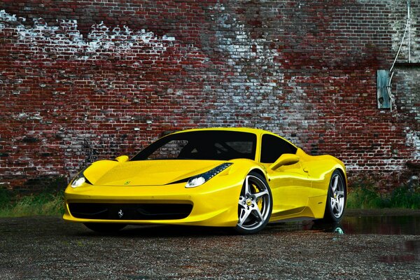 Yellow sports car on a brick wall background
