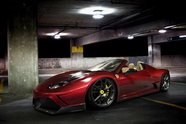 Roter Ferrari Spider auf einem Nachtparkplatz mit mehreren Ebenen