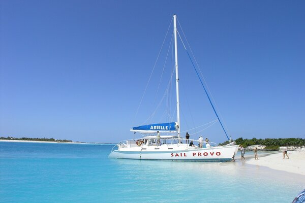 Weißer Sand, weiße Yacht und türkisfarbenes Meer