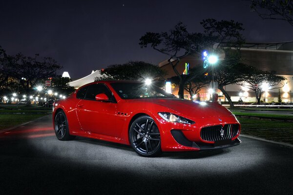 Maserati rosso all aperto alla luce della notte