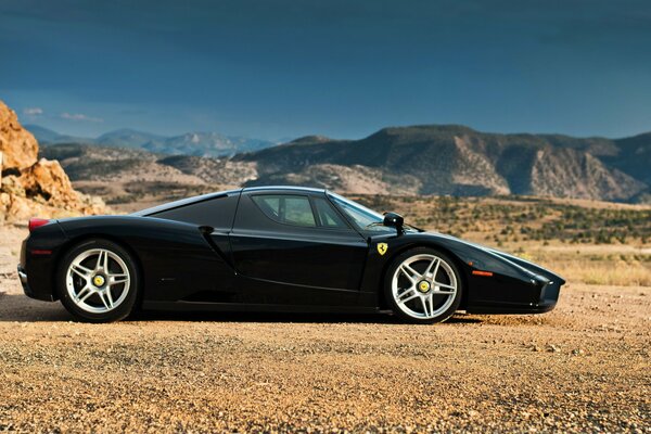 Ferrari Enzo noir dans les montagnes par une journée ensoleillée