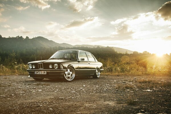 Retro car at dawn on the background of mountains