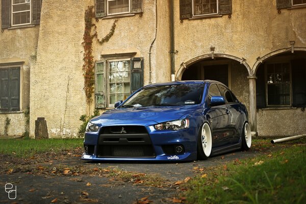 Blue Mitsubishi lancer on the background of an old building