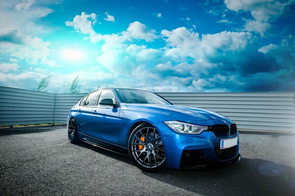 Blauer BMW und blauer Himmel Zaun