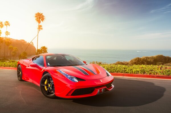 Roter Ferrari auf dem Hintergrund der Wolken und des Ozeans