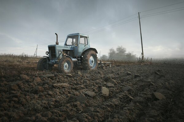 A Belarusian tractor processes a field for sowing