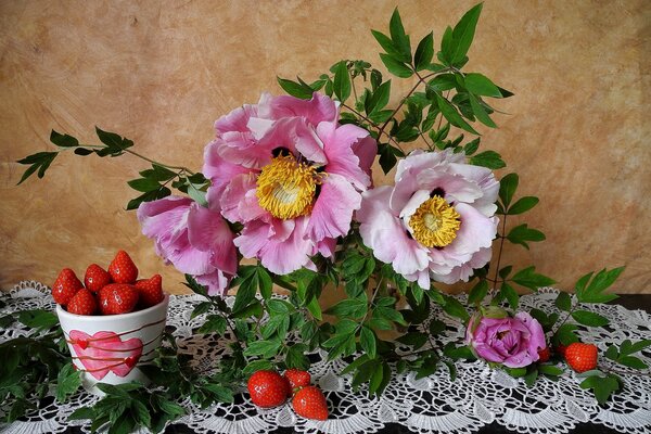 Strawberries and flowers on the table with a tablecloth