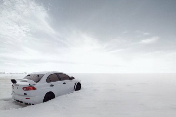 Weißer Mitsubishi in weißen Schneewehen