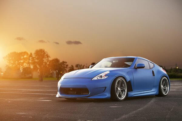 Voiture bleue sur fond de coucher de soleil