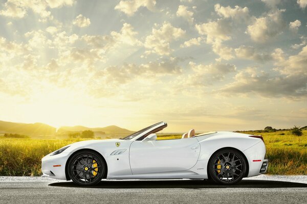 Weißer Ferrari vor dem Hintergrund der aufgehenden Sonne, blauer Himmel in den Feldern von Kalifornien