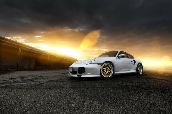 Porsche argento con riflessi al tramonto