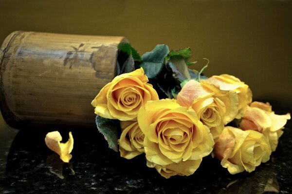 Bouquet de roses jaunes dans un vase tombé