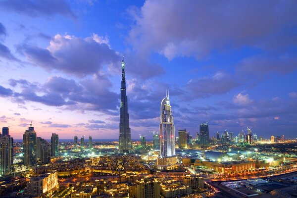 Chmury na niebie nad Dubajem i wieżowce nocnego miasta