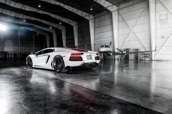 White Lamborghini in an aircraft hangar