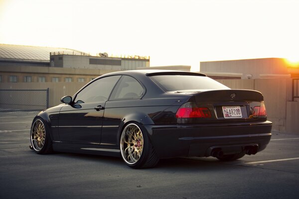 A black Bmw is parked at the base at sunset