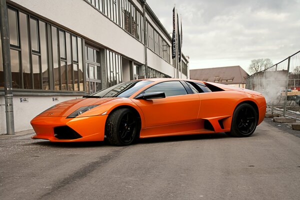 Orange Lamborghini auf Stadt Hintergrund