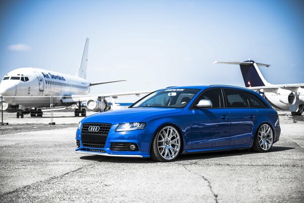 Bleu audi A4 sur le terrain de décollage avec des avions