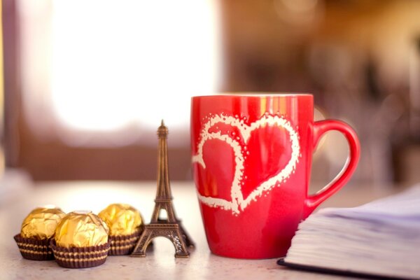Stimmungsvolle Teeparty mit einem Buch, Süßigkeiten und einem Eiffelturm