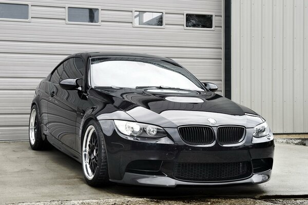 Black bmw on the background of a garage