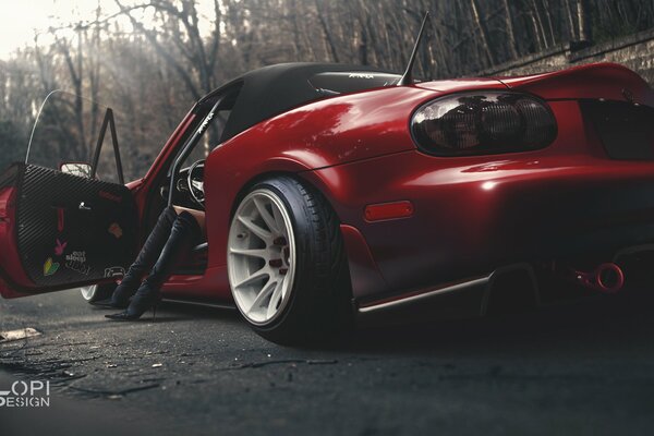 Red mazda car with a woman at the wheel