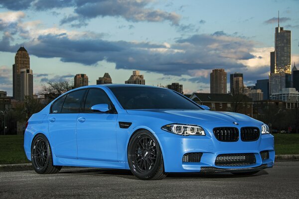 BMW azul en la carretera en el fondo de la metrópoli