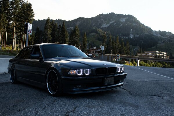 Чёрный BMW на дороге на фоне гор
