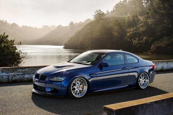 BMW azul en el puente sobre el río