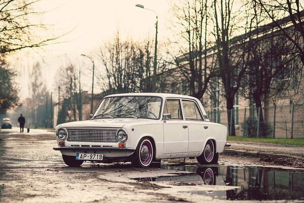 Zhiguli kopek slowly rides through autumn puddles