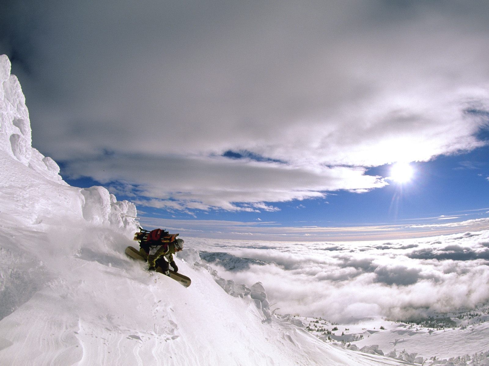 snowboard montañas nieve sol nubes