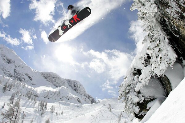 Salta sullo snowboard tra le montagne in inverno