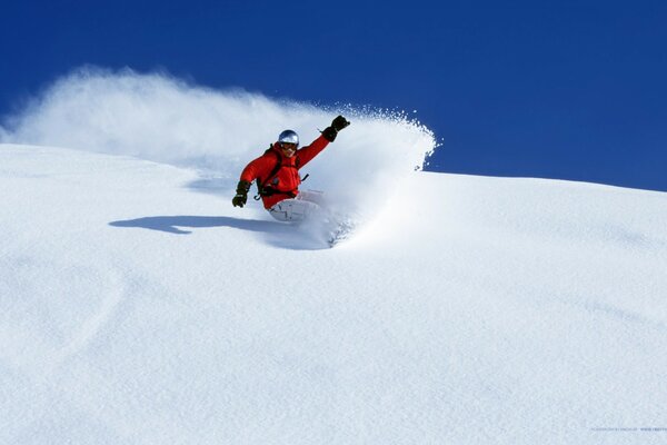 A snowboarder dissects the snow surface