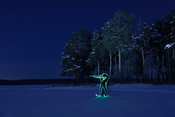 Silhouette of a biathlete against the background of winter trees