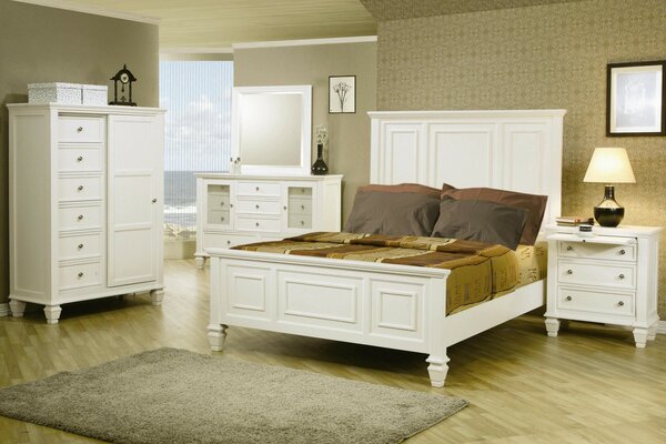 A bed in the middle of the room in white tones