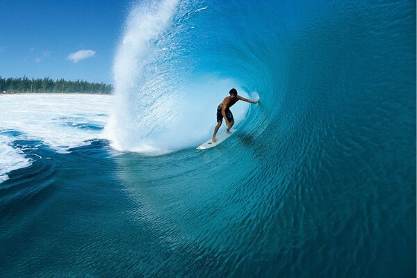 Surfista nadando bajo la ola