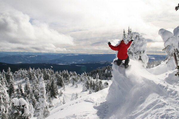 Сноубордист в красной куртке в горах