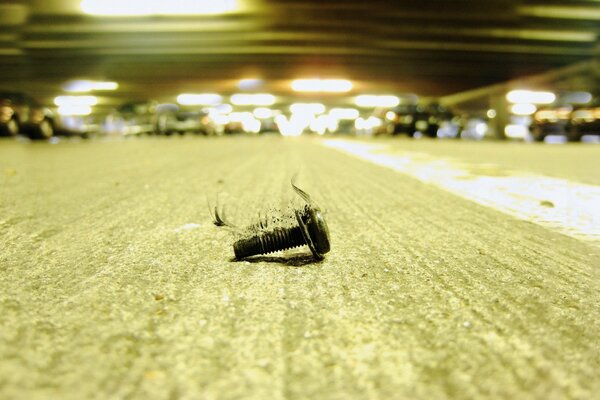 A rusty dirty bolt is lying on the road