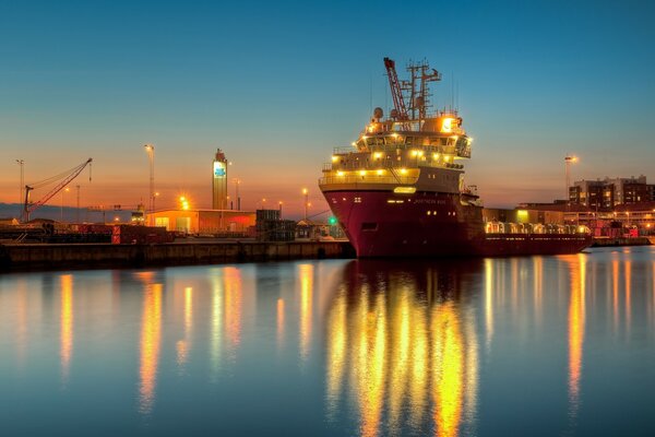 Barcaza en el muelle en la luz de la noche