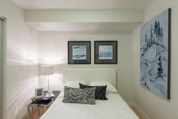 Paintings in the bedroom with pillows on the bed