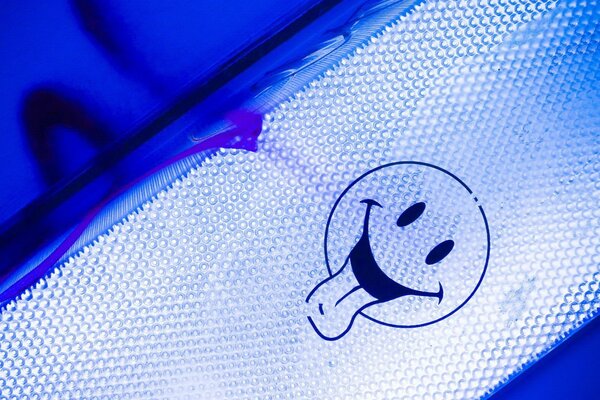 Immagine di un Emoji bianca con la lingua su sfondo blu