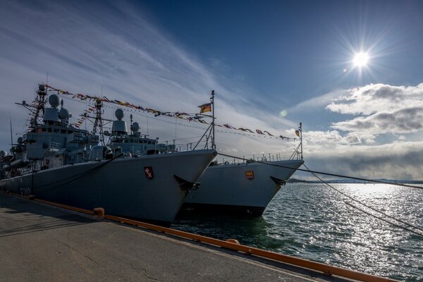 Two frigates on the dock. Bright sun