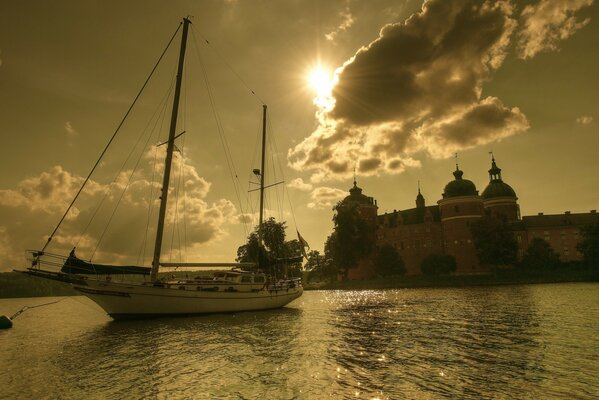 Yacht on the background of sunset at the castle