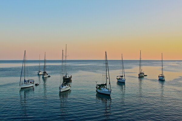 Statki stoją na morzu podczas Błękitnego zachodu Słońca