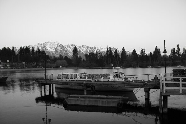 Photo noir et blanc d un bateau sur fond de montagnes