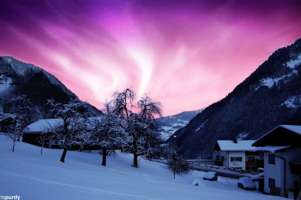 Northern Lights in Alaska. Mountain village. Lilac sky