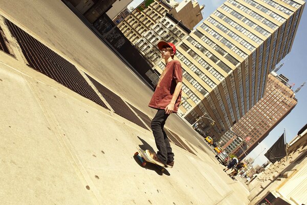 Creative guy on a skateboard on the sidewalk