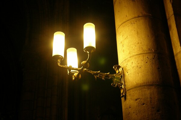 A lantern on a pole in a dark alley