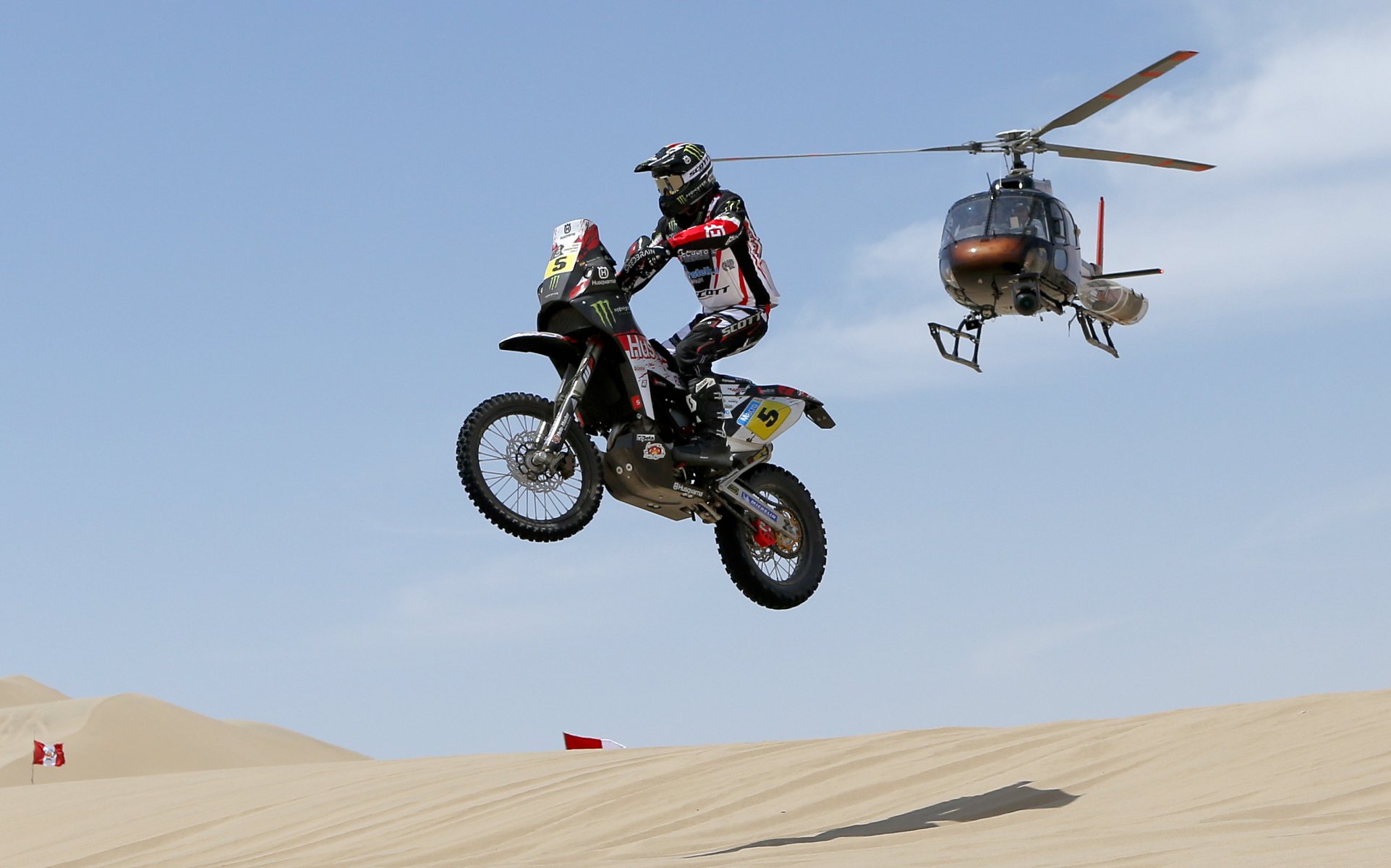 moto hélicoptère planant sable dakar course ombre ciel