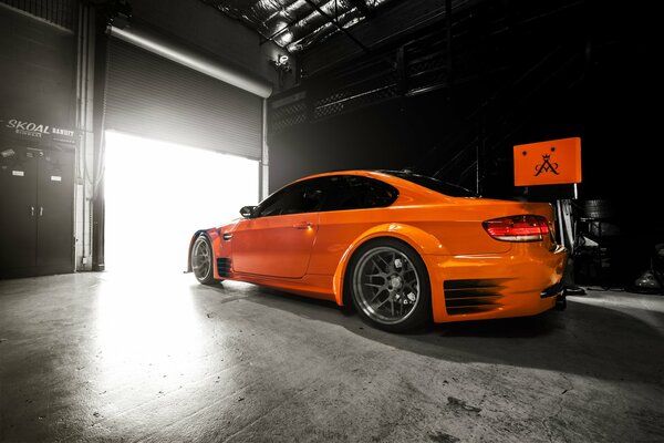 An orange bmw is in the garage