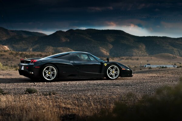 Ferrari Enzo negro en el fondo de las montañas