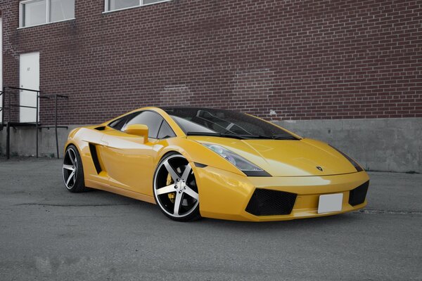 Coche deportivo contra la pared de ladrillo de fondo